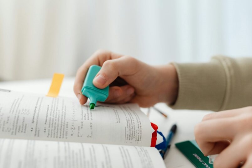 Person diligently studying large CFA curriculum books with a structured plan
