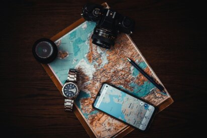 Person planning a trip with map, passport, and travel guide